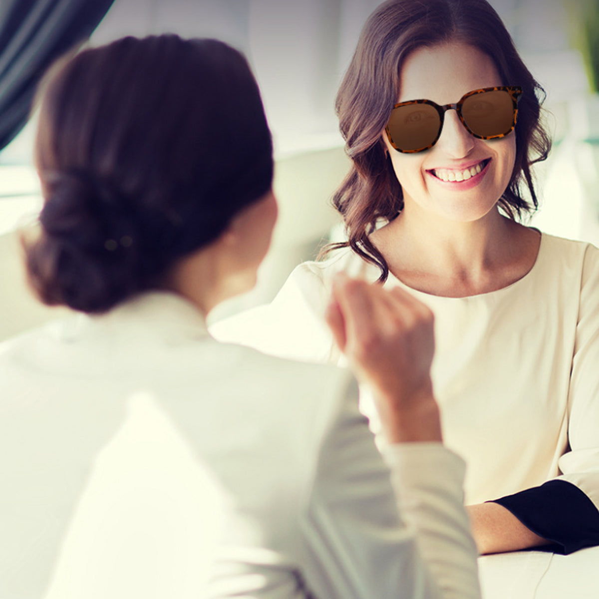 VocaLens AI Smart Sunglasses with photochromic lenses Woman wearing sunglasses smiling at another person in a bright setting