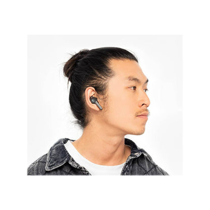 Man wearing wireless earbuds with a plain background with Skullcandy Indy Evo true wireless in-ear headphones in black